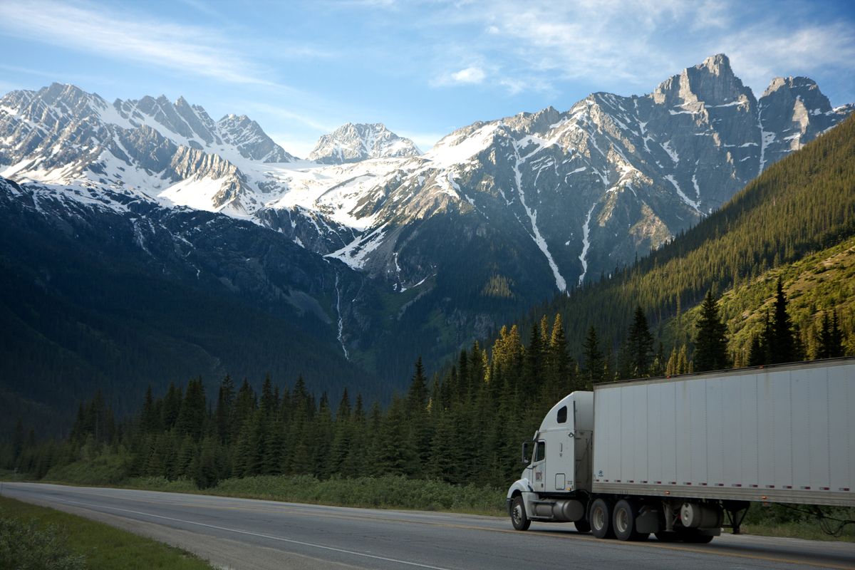 Truck on a highway with mountains behind